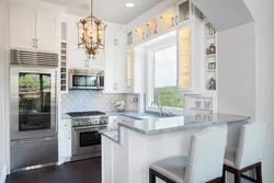 Photo of a kitchen in a house with a window and a bar counter