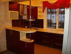 Photo of a kitchen in a house with a window and a bar counter