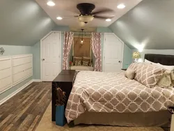 Maili tavan fotoşəkili olan bir taxta evin çardaqındakı yataq otağı