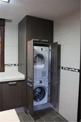 Убудаваная пральная машына ў ваннай у шафу фота