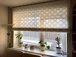 Roman blinds in the kitchen interior with tulle