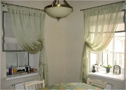 Roman blinds in the kitchen interior with tulle