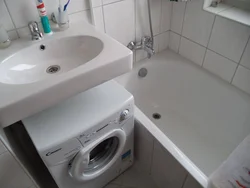Bathtub and washing machine in a small bathroom photo