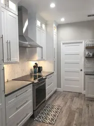 White kitchen with gray floor in the interior