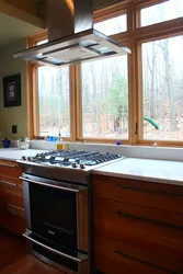 Газовая плита у окна в интерьере кухни