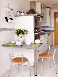 Small kitchen with refrigerator and table photo