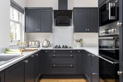 White kitchen design with black appliances