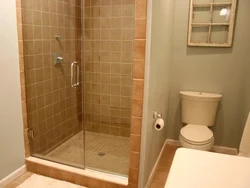 Kiçik bir banyoda kirəmitli duşun fotoşəkili