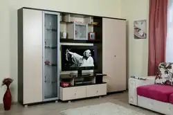 Киім-кешек пен зығыр фотосуретке арналған шкафы бар қонақ бөлмесіндегі қабырға