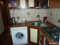 Photo Of A Kitchen With A Refrigerator, Washing Machine And Gas Stove