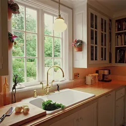 Дызайн кухні з кухонным гарнітурам у акна