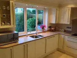 Дызайн кухні з кухонным гарнітурам у акна
