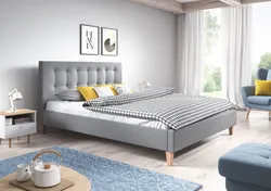 Gray bed with a soft headboard in the bedroom interior photo