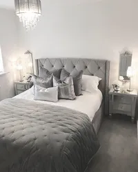 Gray bed with a soft headboard in the bedroom interior photo