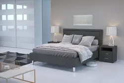 Gray bed with a soft headboard in the bedroom interior photo