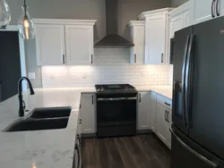 White kitchen black appliances in the interior