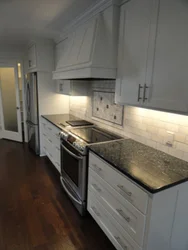 Gray Kitchen With Black Countertop And Apron In The Interior