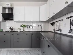 Gray kitchen with black countertop and apron in the interior