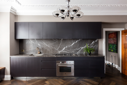 Gray Kitchen With Black Countertop And Apron In The Interior