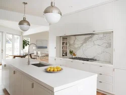 White Kitchen With Marble Countertop And Apron In The Interior