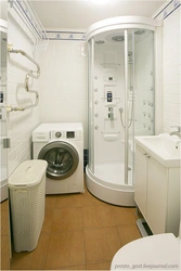 Photo of a bathroom with a shower and a washing machine without a toilet