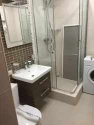 Bathroom interior with shower and washing machine