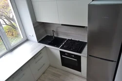 Photo of a small kitchen with a window and a column