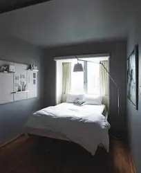 Ложак двухспальны каля акна ў маленькай спальні фота