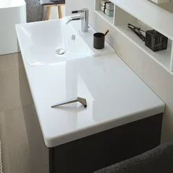 Photo of a bathtub with a sink and a bedside table in the bathroom