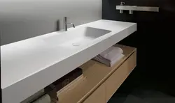 Photo of a bathtub with a sink and a bedside table in the bathroom