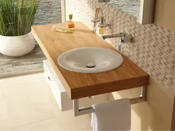 Photo of a bathtub with a sink and a bedside table in the bathroom