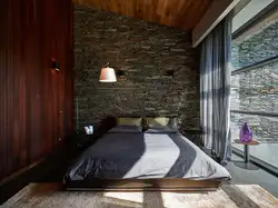 Интерьер спальни с камнем на стене
