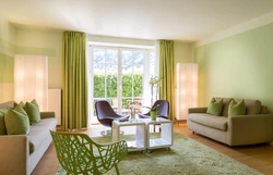 Зеленые шторы в интерьере гостиной с бежевыми обоями
