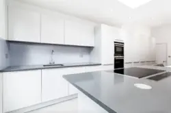 Kitchen With A Gray Countertop In A White Interior And An Apron