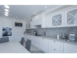 Kitchen with a gray countertop in a white interior and an apron