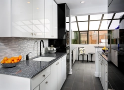 Kitchen with a gray countertop in a white interior and an apron
