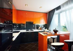 Orange-black kitchen in the interior photo