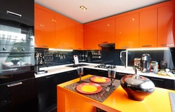 Orange-black kitchen in the interior photo