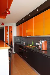 Orange-black kitchen in the interior photo
