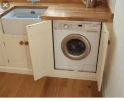 Washing machine in the kitchen under the countertop photo