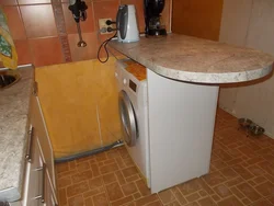 Washing machine in the kitchen under the countertop photo