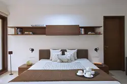 Bedroom interior with shelves on the entire wall