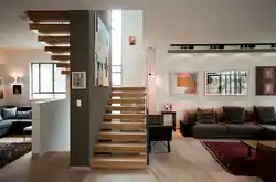 Интерьер гостиной с лестницей на второй