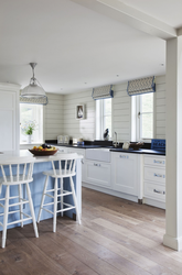 Белая кухня в деревянном доме в интерьере