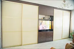 Жатын бөлмесінің фотосуретіндегі теледидарға арналған тауашасы бар жылжымалы шкафтар