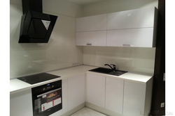 Photo of a kitchen with a white countertop and a black sink