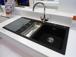 Photo of a kitchen with a white countertop and a black sink