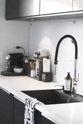 Photo of a kitchen with a white countertop and a black sink