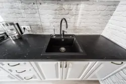 Photo Of A Kitchen With A White Countertop And A Black Sink