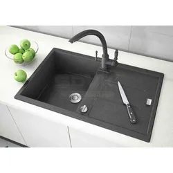 Photo of a kitchen with a white countertop and a black sink